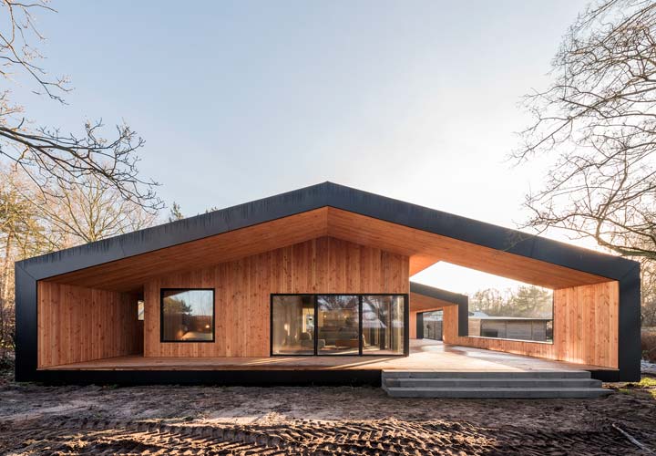 Exterior view of Treldehuset | CEBRA architecture. A roofed outdoor area is internally wrapped in wood.